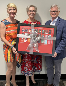 Leona Herzog receives commemorative framed poster from Board of Trustees Chair, Judith Chambers and General Director & CEO, Larry Desrochers.